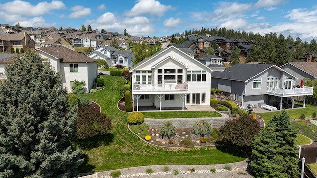 back of property featuring a patio area, a residential view, and a lawn