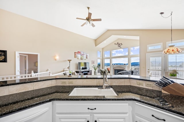 kitchen with ceiling fan, open floor plan, dishwasher, white cabinetry, and a sink