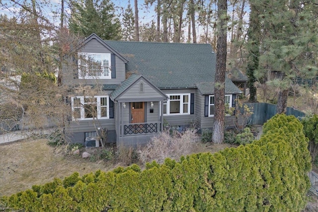 view of front of home featuring roof with shingles and fence