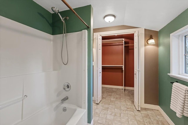 full bathroom with bathtub / shower combination, lofted ceiling, a spacious closet, and baseboards