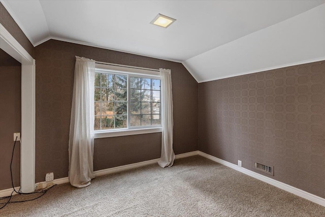 additional living space featuring wallpapered walls, vaulted ceiling, carpet, and visible vents