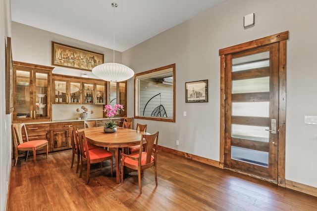 dining area featuring dark wood-type flooring and baseboards