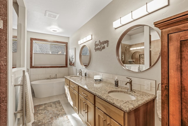 bathroom featuring tile patterned floors, a soaking tub, double vanity, and a sink