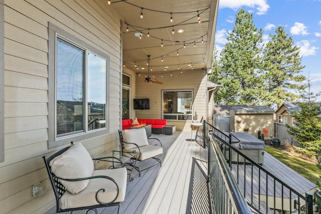 wooden terrace with an outdoor living space and a ceiling fan