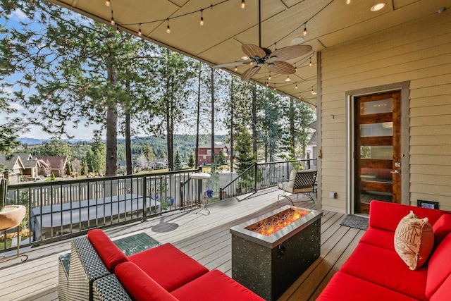 wooden deck featuring an outdoor living space with a fire pit and a ceiling fan