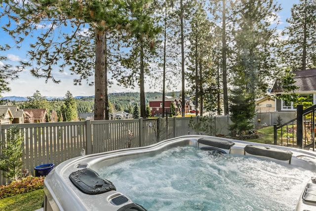 view of pool with a mountain view, a hot tub, and fence