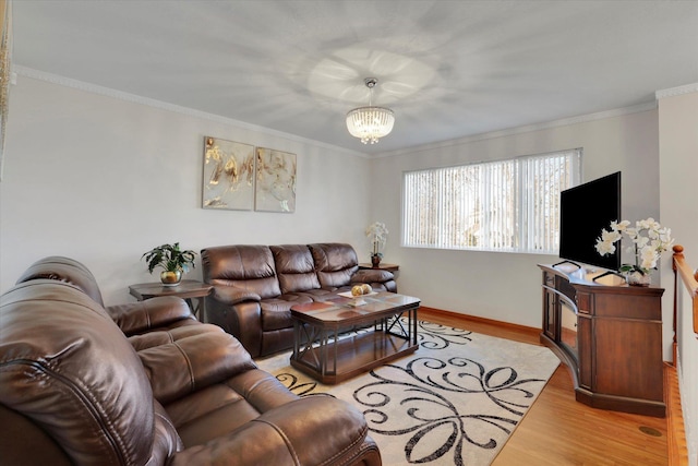 living room with an inviting chandelier, crown molding, baseboards, and light wood finished floors