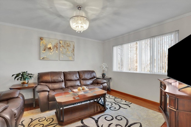 living room featuring light wood-type flooring, baseboards, a notable chandelier, and crown molding