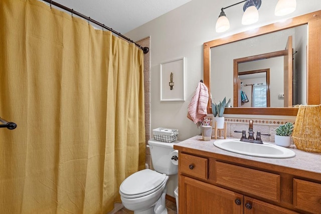 bathroom with curtained shower, toilet, and vanity