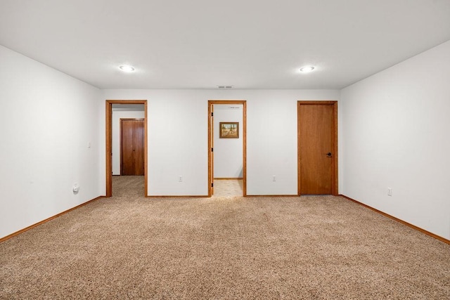 unfurnished room featuring baseboards and light colored carpet