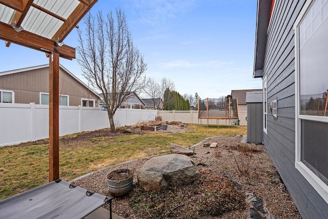 view of yard with a fenced backyard and a trampoline