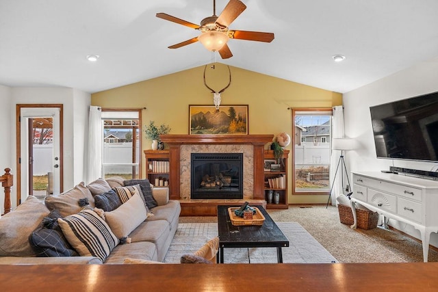 living area featuring carpet floors, a ceiling fan, lofted ceiling, and a premium fireplace