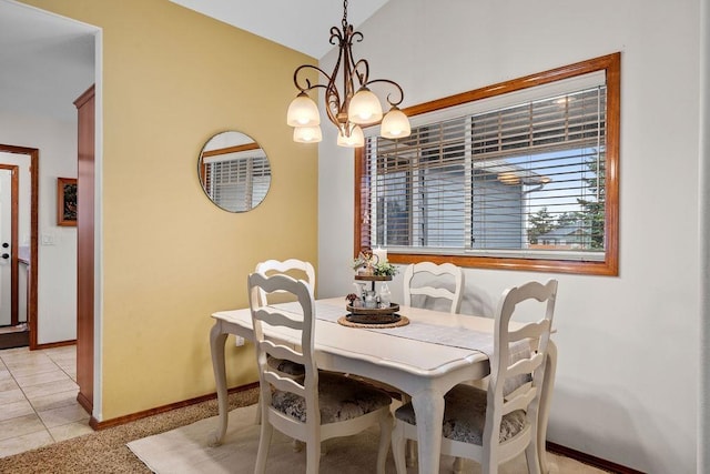 dining area with light tile patterned floors, baseboards, lofted ceiling, and an inviting chandelier