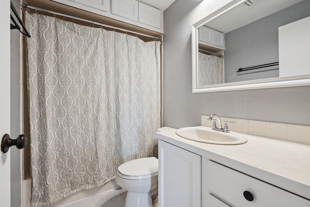 full bathroom with toilet, vanity, and a textured wall