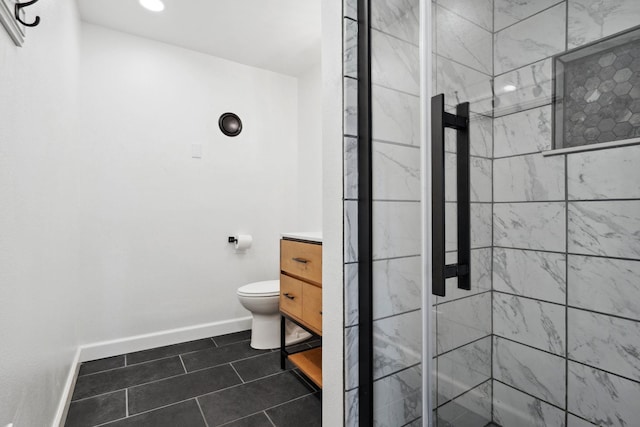 bathroom featuring vanity, baseboards, tile patterned flooring, a shower stall, and toilet