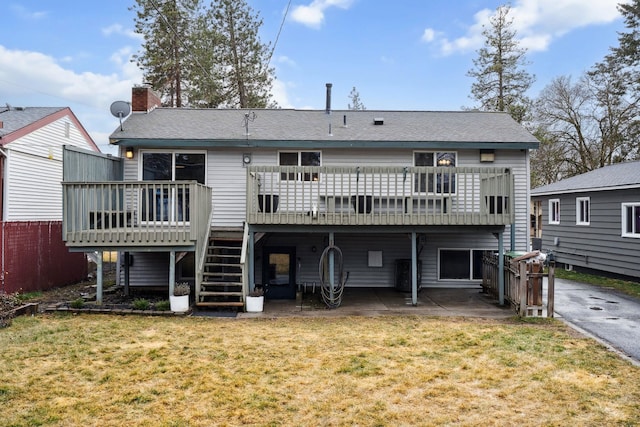 back of property with a yard, a deck, stairs, and a patio area