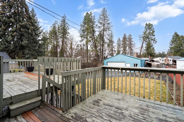 deck featuring a garage, an outbuilding, and a yard