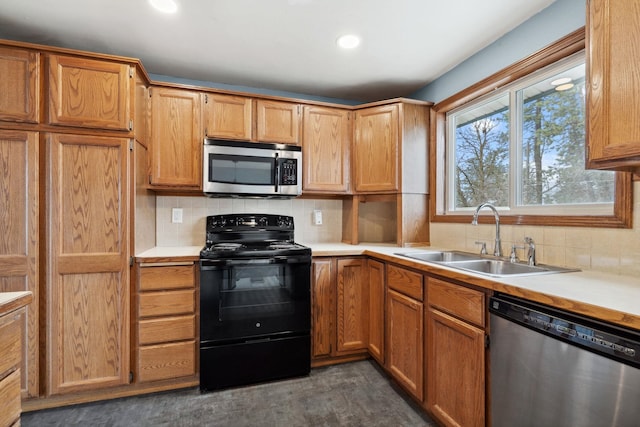 kitchen with appliances with stainless steel finishes, light countertops, and a sink