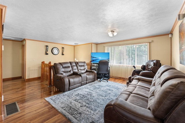 living room featuring visible vents, baseboards, wood finished floors, and ornamental molding