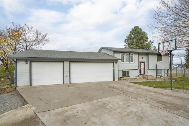 split foyer home with an attached garage, fence, and driveway