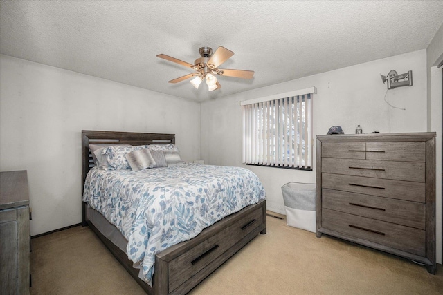 bedroom featuring a textured ceiling, ceiling fan, baseboards, and light carpet