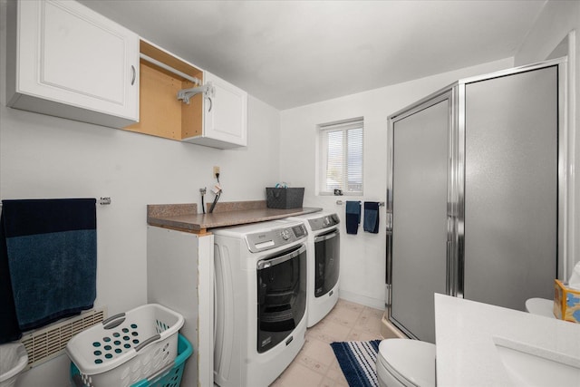 clothes washing area featuring light floors, washing machine and dryer, and laundry area