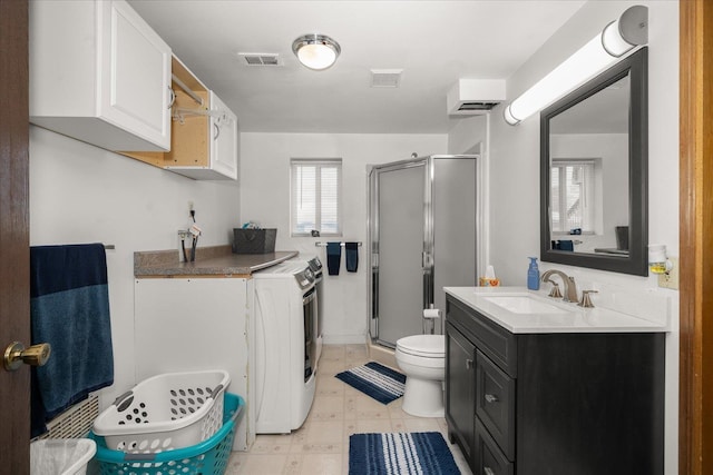 bathroom featuring vanity, washer / dryer, visible vents, and a stall shower