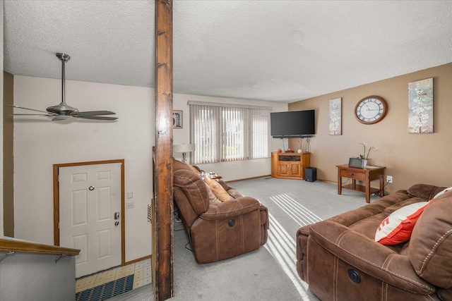 carpeted living room with a ceiling fan, baseboards, and a textured ceiling