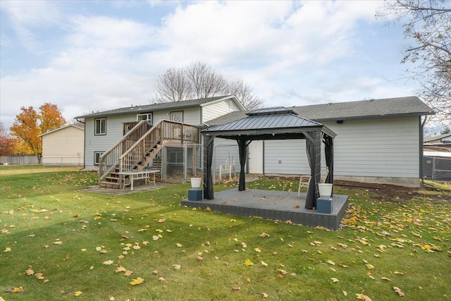 rear view of house featuring fence, stairs, a gazebo, a lawn, and a patio area