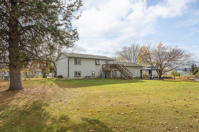 back of house featuring stairway, fence, a wooden deck, a yard, and a gazebo