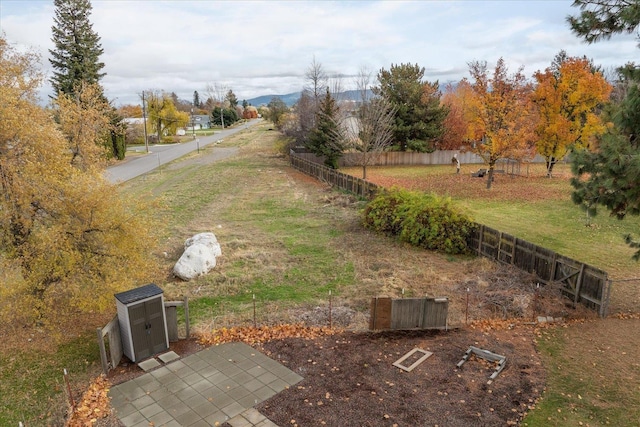 view of yard featuring a storage unit, an outbuilding, and fence