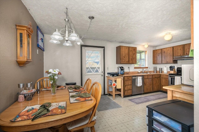 kitchen with light floors, an inviting chandelier, a sink, stainless steel appliances, and light countertops