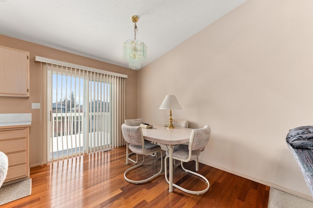 dining area with a chandelier, light wood-type flooring, and baseboards