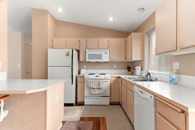 kitchen featuring light brown cabinets, light countertops, lofted ceiling, white appliances, and a sink