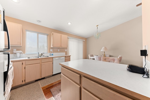 kitchen featuring light wood finished floors, light brown cabinets, dishwasher, light countertops, and a sink