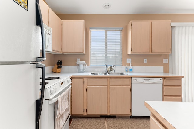 kitchen with white appliances, light countertops, light brown cabinetry, and a sink