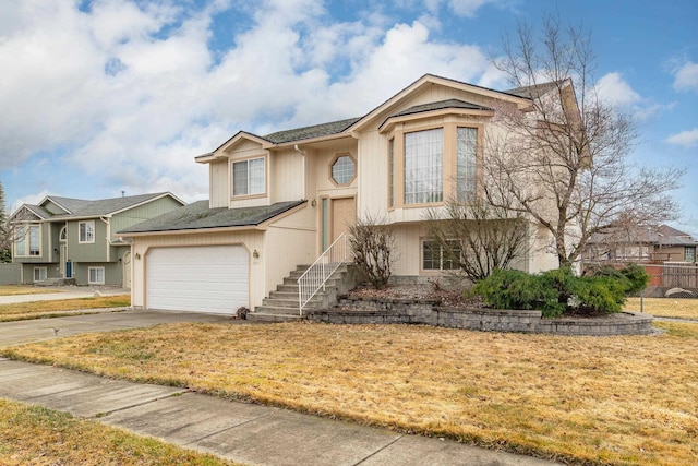 bi-level home with concrete driveway and fence