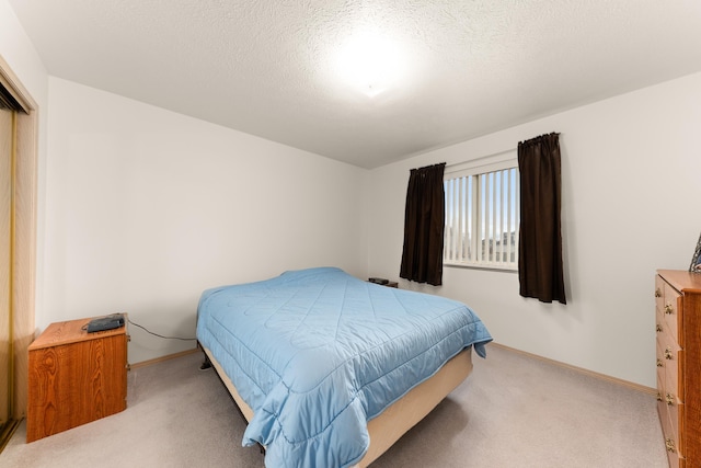 bedroom featuring baseboards, carpet, and a textured ceiling