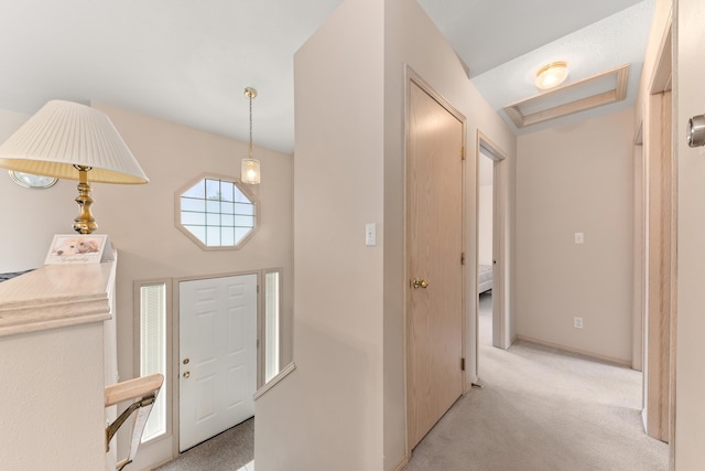 foyer featuring light colored carpet and baseboards