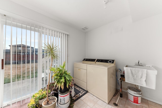 laundry room featuring a sink, baseboards, visible vents, and separate washer and dryer