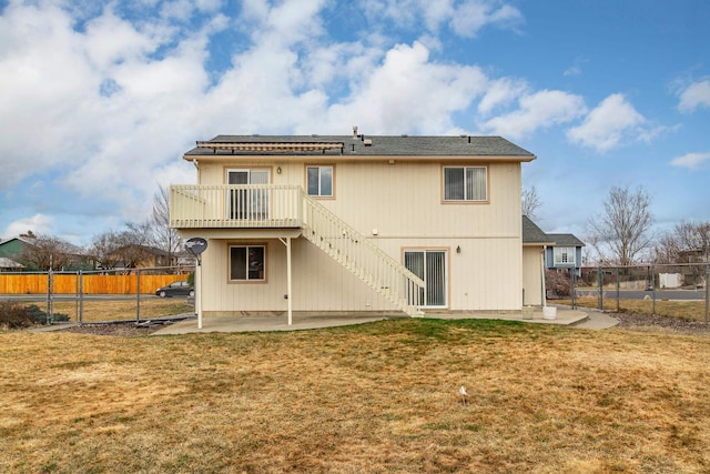 rear view of property with a fenced backyard, a deck, a lawn, and a patio