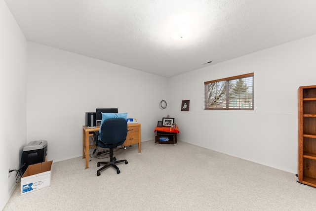 home office with carpet flooring, visible vents, and a textured ceiling