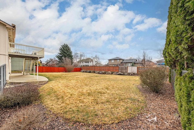 view of yard featuring a wooden deck, a patio, a fenced backyard, and stairs