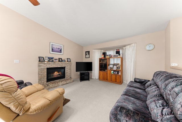 living area featuring light carpet, a ceiling fan, a fireplace, and vaulted ceiling