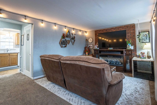 carpeted living room with a sink and baseboards