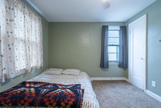 carpeted bedroom featuring ceiling fan and baseboards