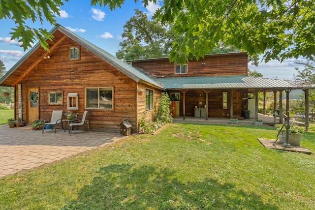 back of property featuring a patio area, a lawn, and metal roof