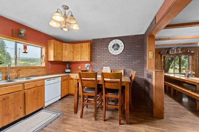 kitchen with light wood-style flooring, a sink, light countertops, dishwasher, and a chandelier