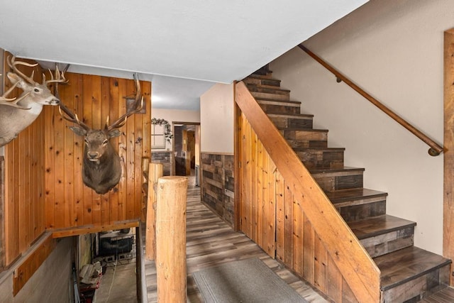 stairway with wood finished floors and wood walls