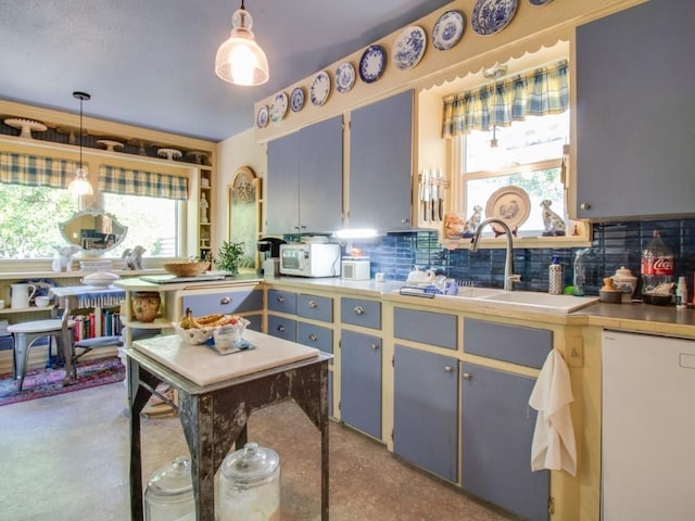 kitchen with white appliances, pendant lighting, tasteful backsplash, and a sink